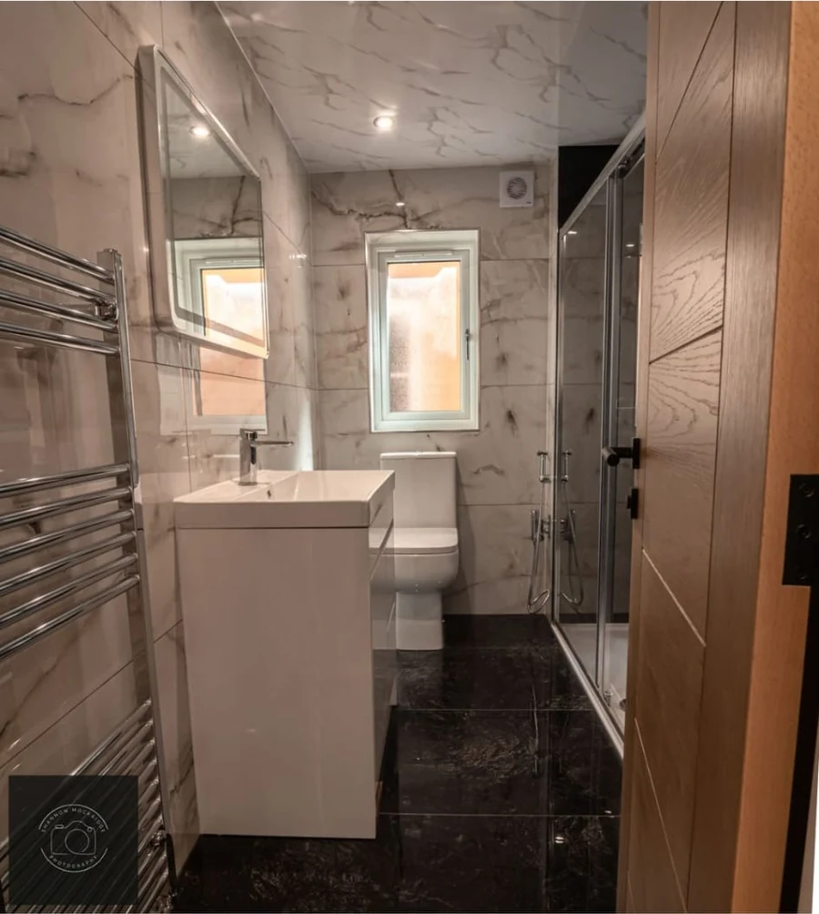 Finished bathroom with vanity unit and tiled walls in Coventry by Godiva Decorators (completed)