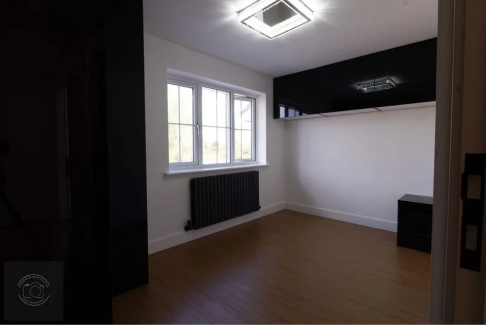 Bedroom with a dark feature wall in Coventry by Godiva Decorators (completed)