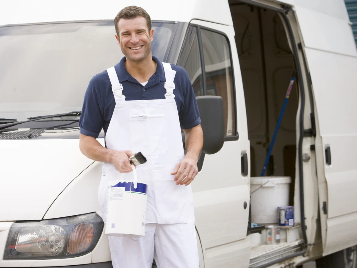 Smiling painter standing ready for home renovation decorating work